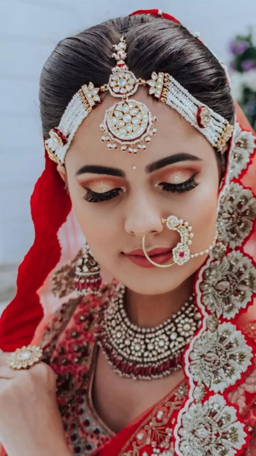 Photo of Bride wearing dewy base and nude lips with her red lehenga